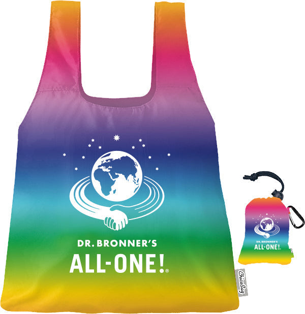A vibrant, reusable tote bag displaying a rainbow gradient and DR. BRONNERS ALL ONE text with a globe and handshake logo. Includes a compact, matching pouch for easy storage