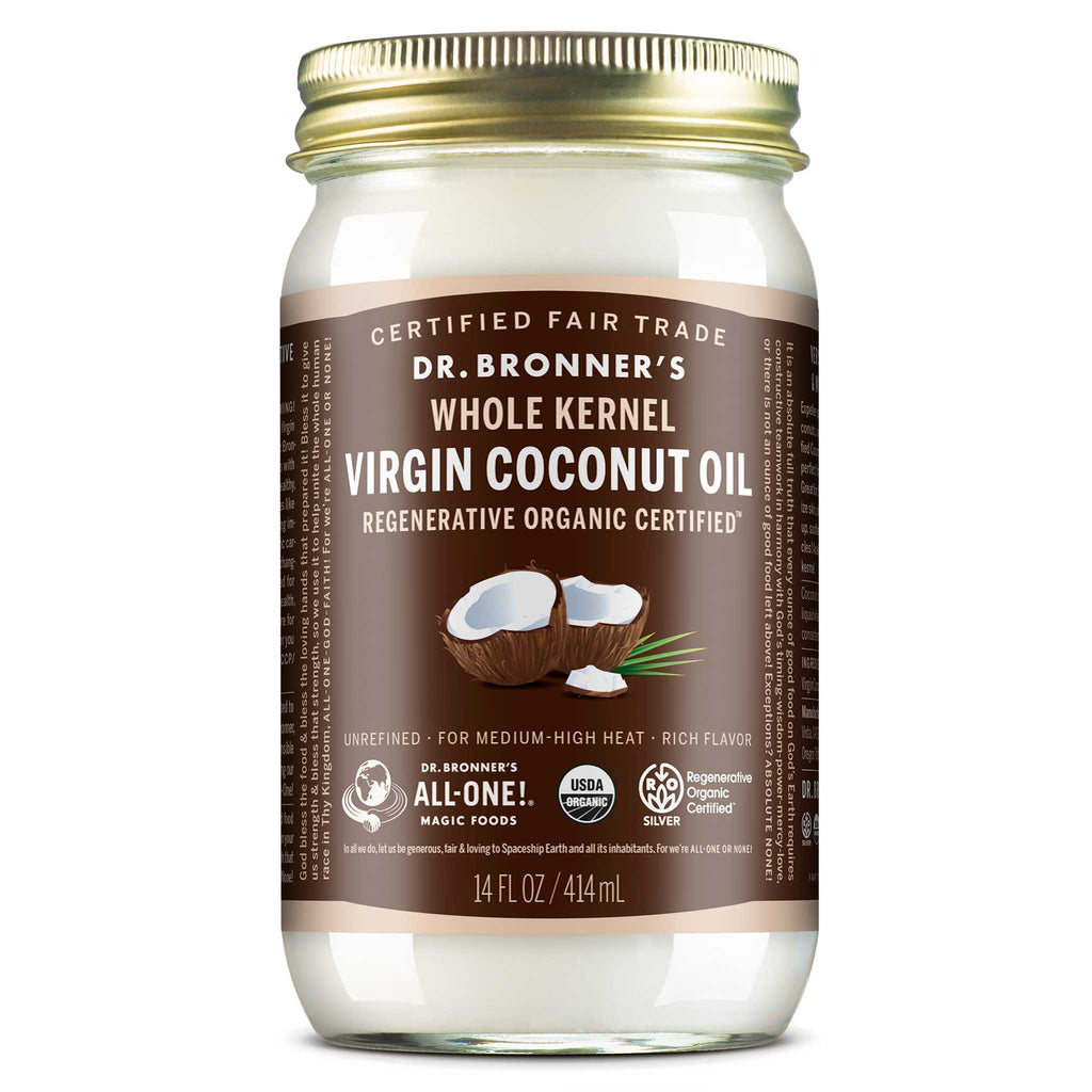 A clear glass jar of Dr. Bronners Whole Kernel Virgin Coconut Oil features a golden lid and brown label with white text. Displaying images of coconuts, it is regenerative organic certified [14 oz]