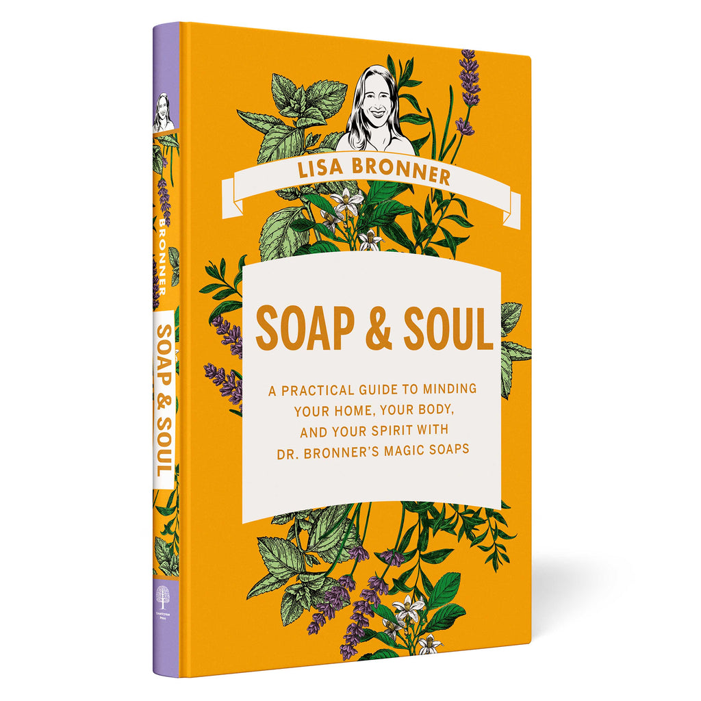 A book titled SOAP SOUL by Lisa Bronner features an illustrated cover with herbs and plants. Text states A Practical Guide to Minding Your Home, Your Body, and Your Spirit with Dr. Bronners Magic Soaps