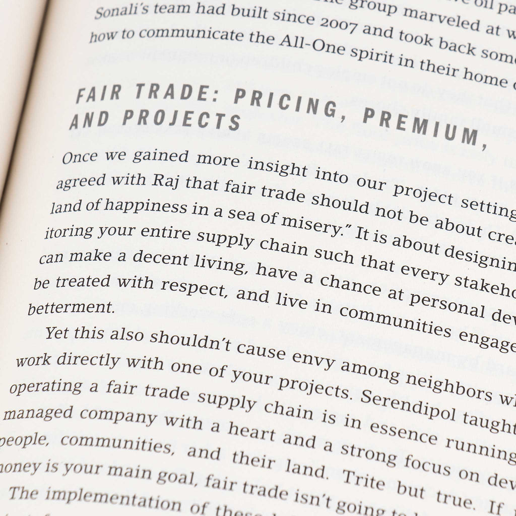 A close up of a book page, focusing on a chapter titled Fair Trade Pricing, Premium, and Projects. The text discusses fair trade concepts, emphasizing equitable supply chain practices for community betterment